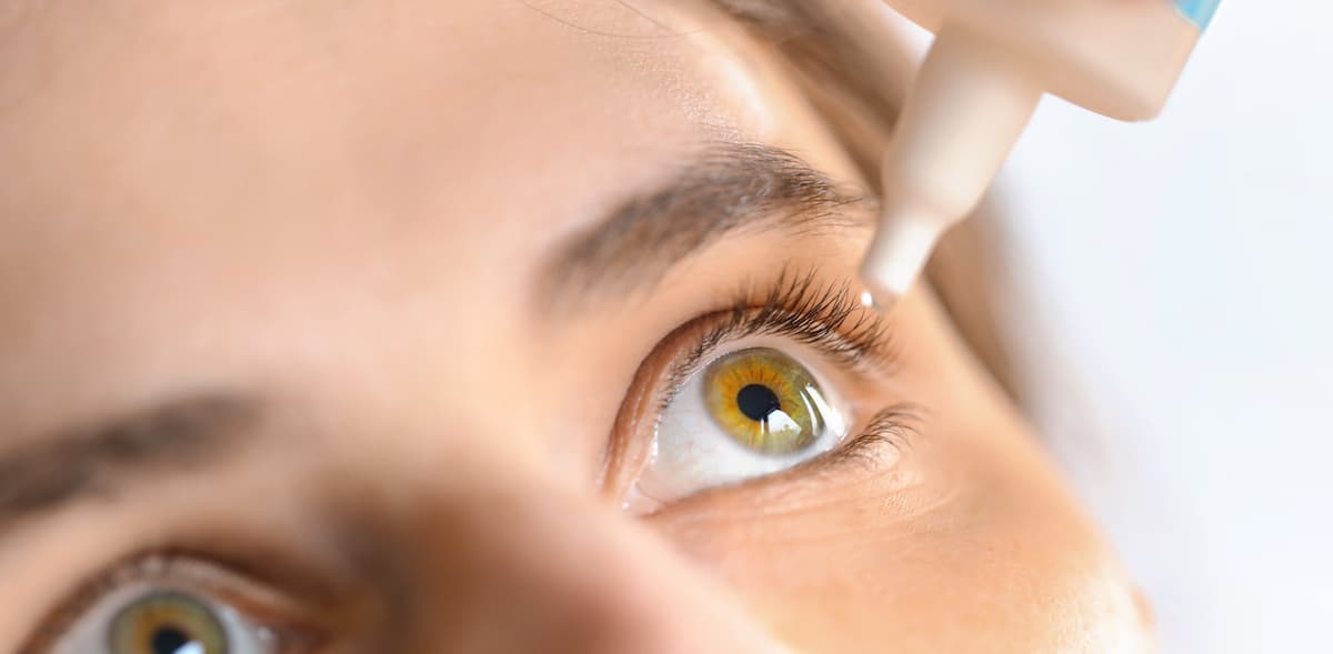 Woman applying eye drop