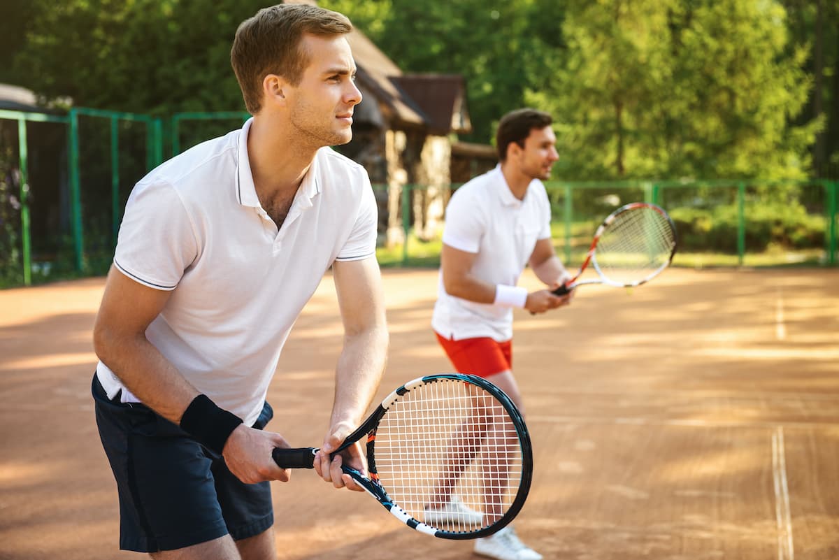 2 young men playing tennis