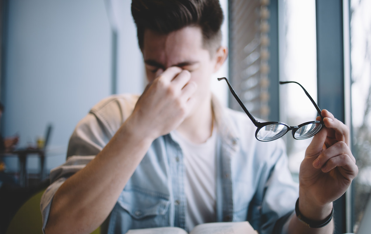 Man rubbing irritated eyes
