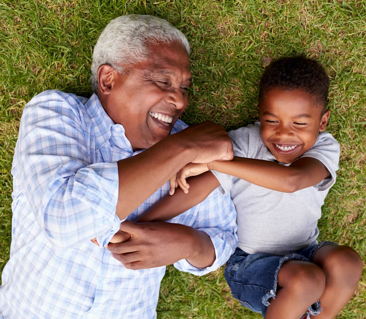 grandpa and grandchild playing in grass